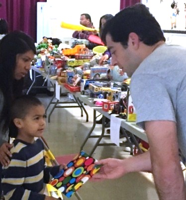 Michael Camarda distributing books at the Santa Ana's El Salvador Community Center