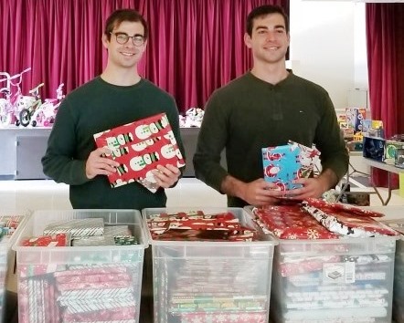 Michael and Nick Camarda distributing gift-wrapped books